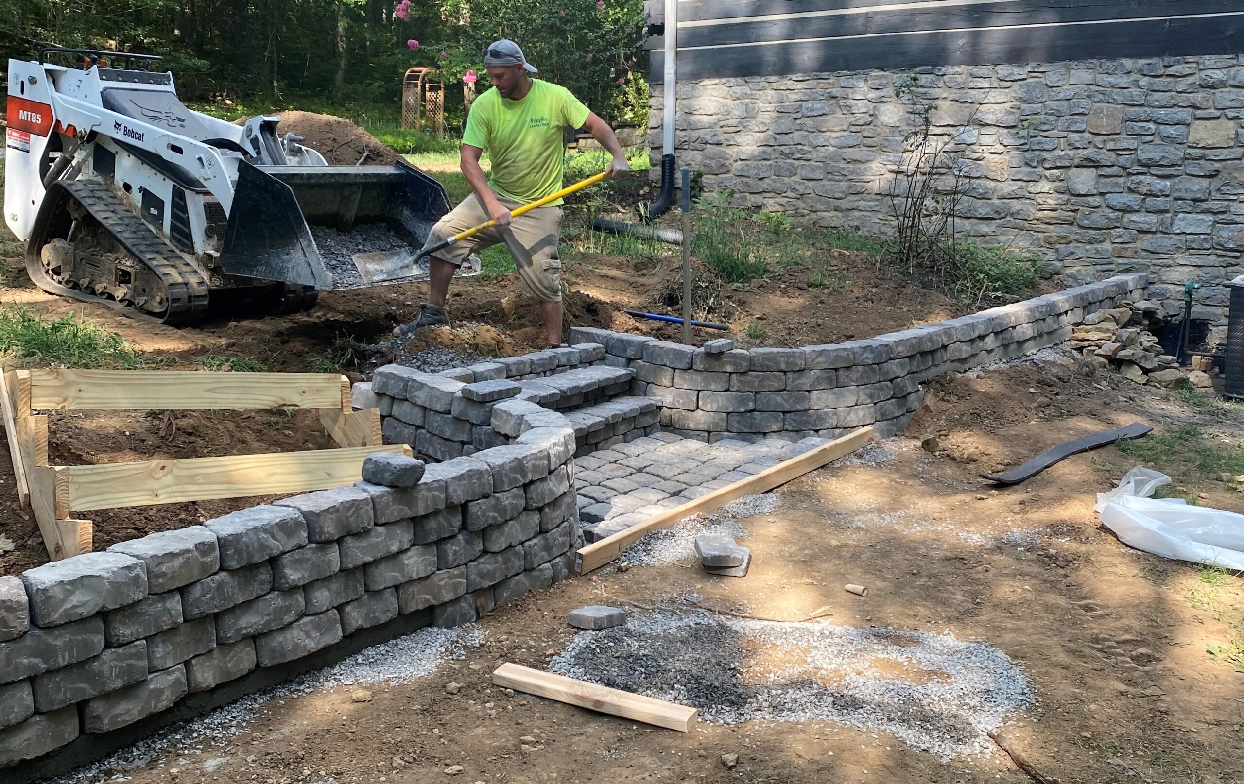 Paver patio with a stone seat wall and landscape lighting, built by TN Hardscapes
